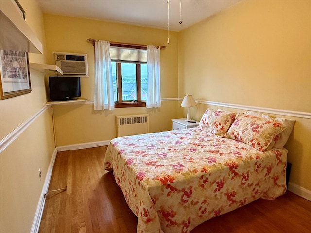 59-47 69th Ln Unit A, Maspeth, NY 11378 - bedroom featuring radiator, wood finished floors, and a wall mounted AC