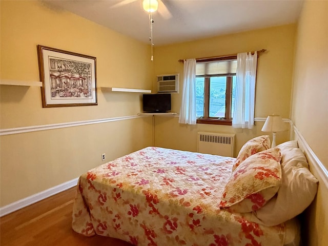 59-47 69th Ln Unit A, Maspeth, NY 11378 - bedroom featuring radiator, wood finished floors, a wall mounted AC, and a ceiling fan