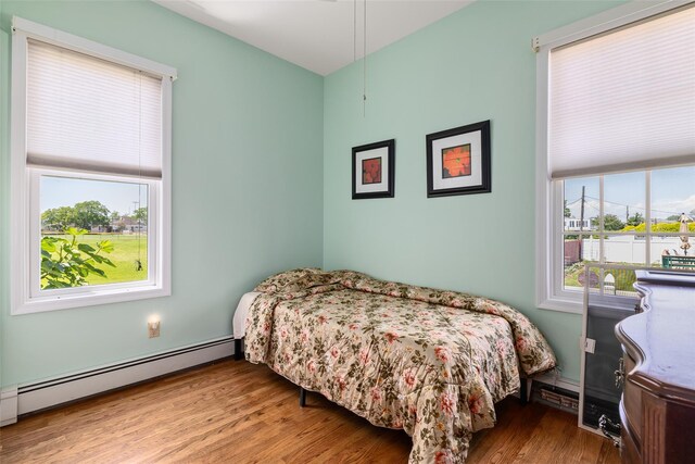 248 Delaware Ave, Island Park, NY 11558 - bedroom with a baseboard heating unit and wood finished floors