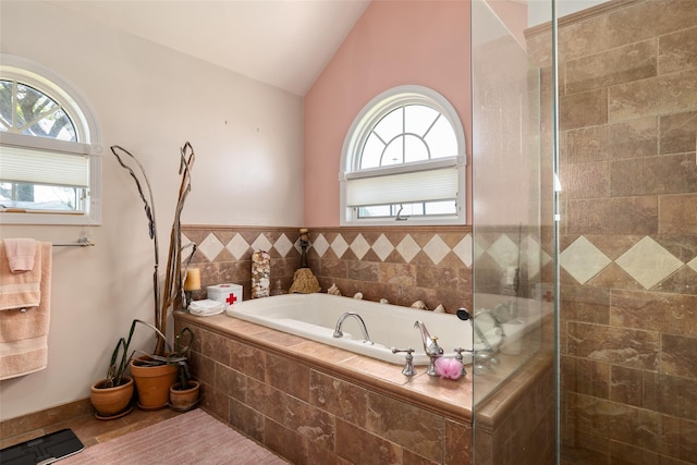 248 Delaware Ave, Island Park, NY 11558 - bathroom with plenty of natural light, a garden tub, vaulted ceiling, and tiled shower