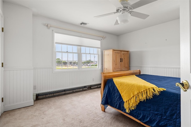 248 Delaware Ave, Island Park, NY 11558 - carpeted bedroom featuring baseboard heating, wainscoting, and ceiling fan