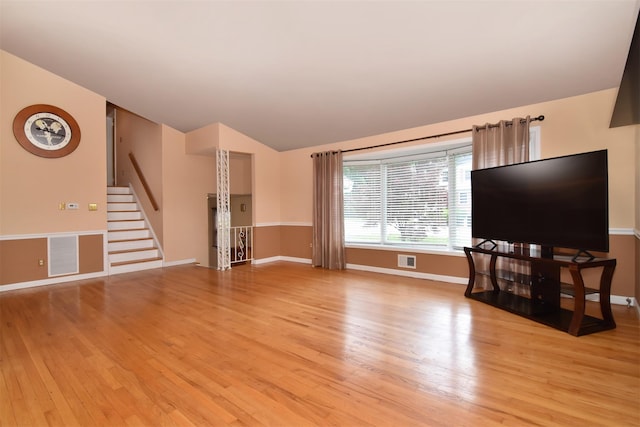 38 Balmoral Cres, White Plains, NY 10607 - unfurnished living room featuring light wood finished floors, stairs, and lofted ceiling
