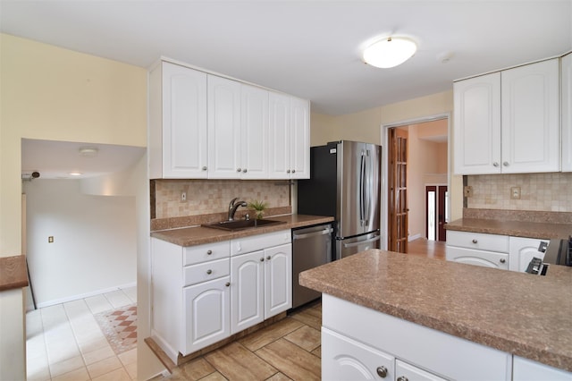 38 Balmoral Cres, White Plains, NY 10607 - kitchen featuring stainless steel appliances, decorative backsplash, white cabinetry, and dark countertops