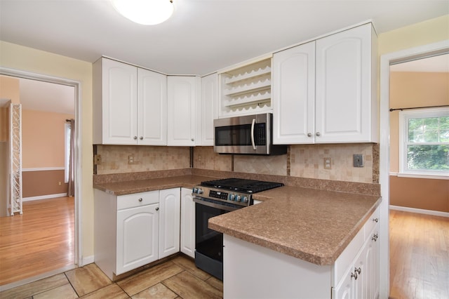 38 Balmoral Cres, White Plains, NY 10607 - kitchen featuring stainless steel appliances, white cabinetry, decorative backsplash, and light wood-style floors