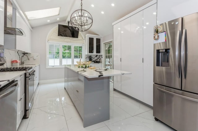 1 Howland Rd, East Rockaway, NY 11518 - kitchen featuring stainless steel appliances, modern cabinets, wall chimney range hood, white cabinets, and lofted ceiling