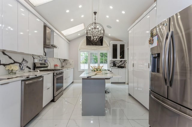 1 Howland Rd, East Rockaway, NY 11518 - kitchen with appliances with stainless steel finishes, modern cabinets, wall chimney exhaust hood, white cabinets, and a chandelier