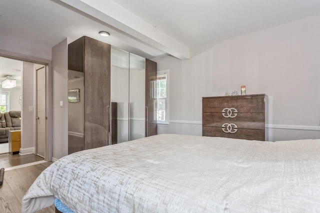 1 Howland Rd, East Rockaway, NY 11518 - bedroom featuring wood finished floors, beamed ceiling, and multiple windows