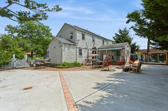 1 Howland Rd, East Rockaway, NY 11518 - rear view of house with a gate, outdoor dining space, and a patio area
