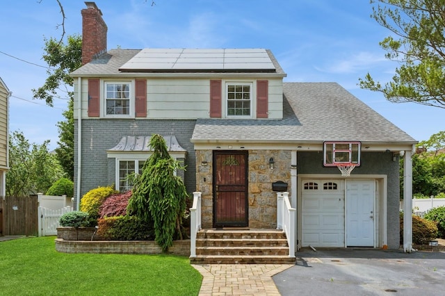 1 Howland Rd, East Rockaway, NY 11518 - view of front of house featuring solar panels, a chimney, a garage, asphalt driveway, and a shingled roof