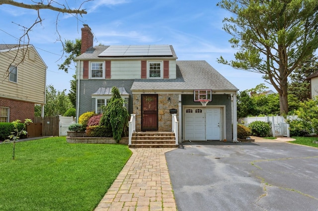 1 Howland Rd, East Rockaway, NY 11518 - view of front facade featuring a chimney, solar panels, driveway, a gate, and a garage