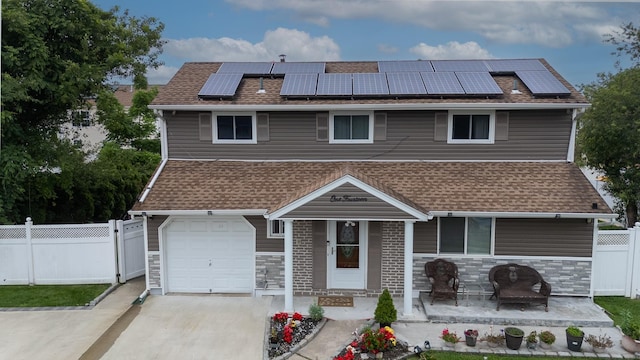 114 Cone Ave, Central Islip, NY 11722 - townhome / multi-family property featuring an attached garage, roof mounted solar panels, stone siding, and roof with shingles