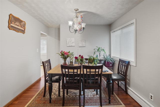 114 Cone Ave, Central Islip, NY 11722 - dining area featuring baseboard heating, dark wood-style flooring, a chandelier, and a textured ceiling