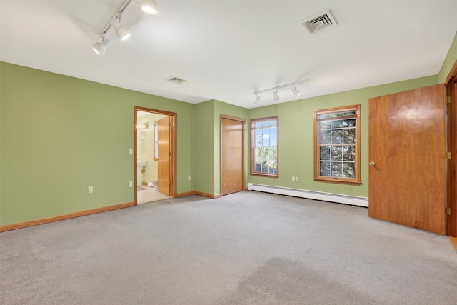 561 Toleman Rd, Rock Tavern, NY 12575 - unfurnished bedroom featuring track lighting, a baseboard heating unit, carpet, and connected bathroom