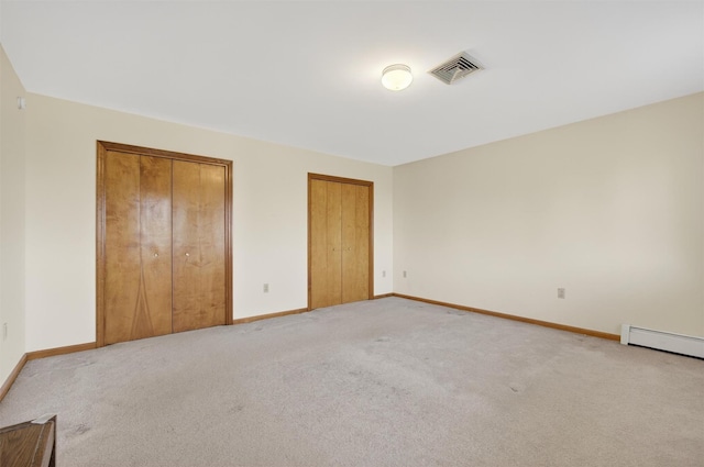 561 Toleman Rd, Rock Tavern, NY 12575 - unfurnished bedroom featuring multiple closets, carpet floors, and baseboard heating