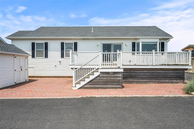 100 Deforest Rd Unit 701, Montauk, NY 11954 - view of front of house with a deck, a shingled roof, and an outbuilding