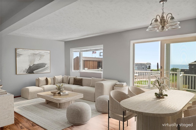 100 Deforest Rd Unit 701, Montauk, NY 11954 - living room featuring a chandelier, wood finished floors, and a textured ceiling