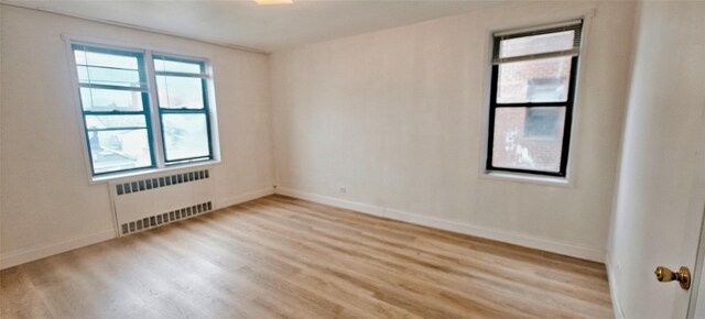 6615 Wetherole St Unit D12, Rego Park, NY 11374 - unfurnished room with radiator heating unit and light wood-style flooring