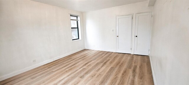 6615 Wetherole St Unit D12, Rego Park, NY 11374 - unfurnished bedroom with wood finished floors and baseboards