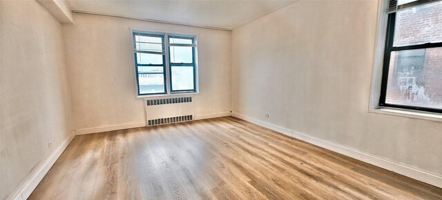 6615 Wetherole St Unit D12, Rego Park, NY 11374 - empty room with radiator and wood finished floors