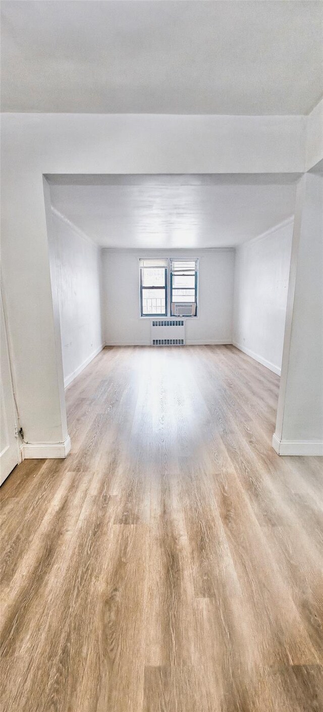 6615 Wetherole St Unit D12, Rego Park, NY 11374 - spare room with light wood-style floors and radiator heating unit