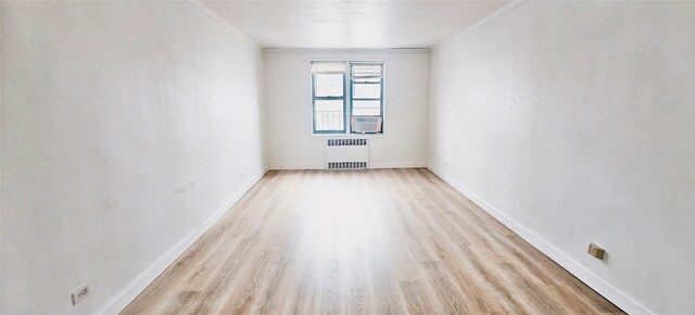 6615 Wetherole St Unit D12, Rego Park, NY 11374 - empty room with radiator heating unit and light wood-style flooring