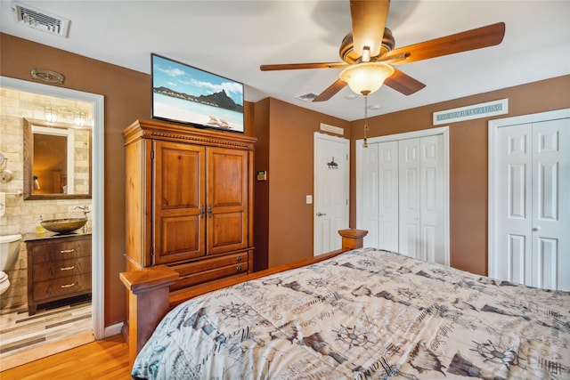 1 Angelica Ct, West Babylon, NY 11704 - bedroom featuring light wood-style floors, two closets, ensuite bath, and ceiling fan