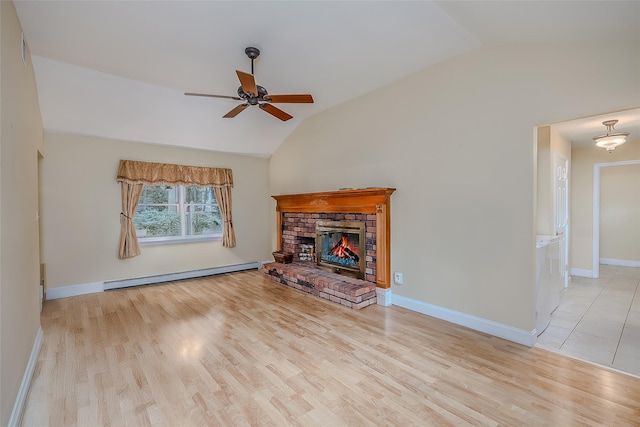 101 Wilson Dr, Port Jefferson Village, NY 11777 - unfurnished living room featuring baseboard heating, vaulted ceiling, ceiling fan, wood finished floors, and a stone fireplace