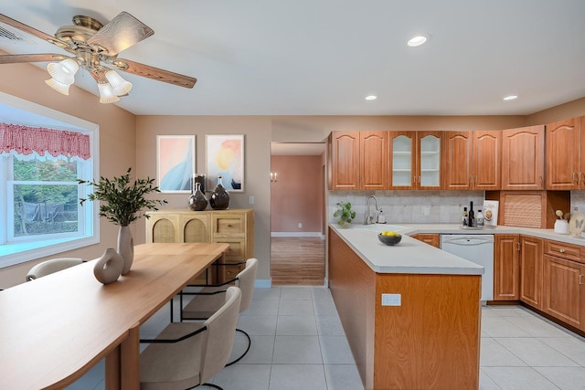 101 Wilson Dr, Port Jefferson Village, NY 11777 - kitchen with dishwasher, light countertops, glass insert cabinets, backsplash, and a peninsula