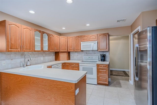101 Wilson Dr, Port Jefferson Village, NY 11777 - kitchen featuring white appliances, a peninsula, light tile patterned floors, light countertops, and decorative backsplash