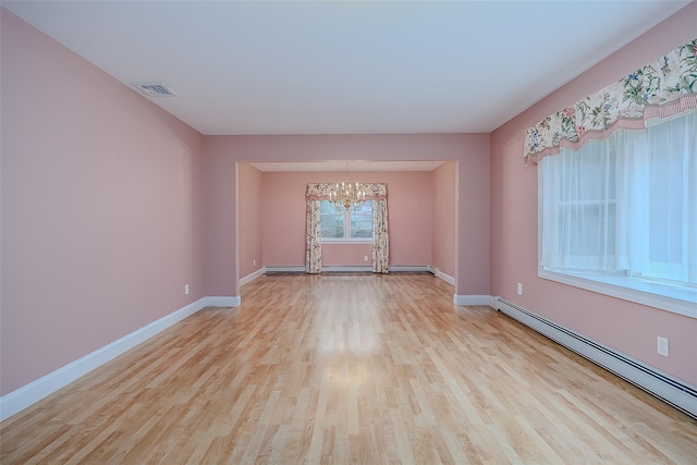 101 Wilson Dr, Port Jefferson Village, NY 11777 - spare room with baseboard heating, a chandelier, and wood finished floors