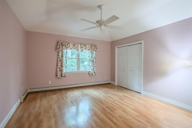 101 Wilson Dr, Port Jefferson Village, NY 11777 - unfurnished bedroom featuring baseboard heating, wood finished floors, a closet, a ceiling fan, and lofted ceiling