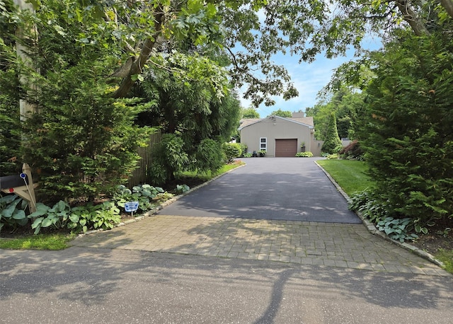 1778 Spur Dr S, Islip, NY 11751 - obstructed view of property featuring driveway, stucco siding, and an attached garage