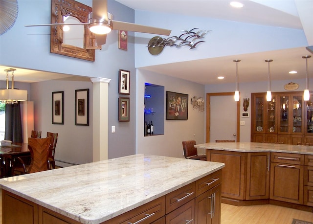 1778 Spur Dr S, Islip, NY 11751 - kitchen with brown cabinets, a kitchen island, recessed lighting, light stone countertops, and high vaulted ceiling