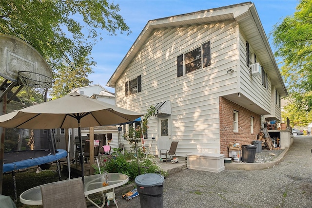 1222 Brook St, Peekskill, NY 10566 - rear view of property featuring a trampoline, brick siding, and a patio