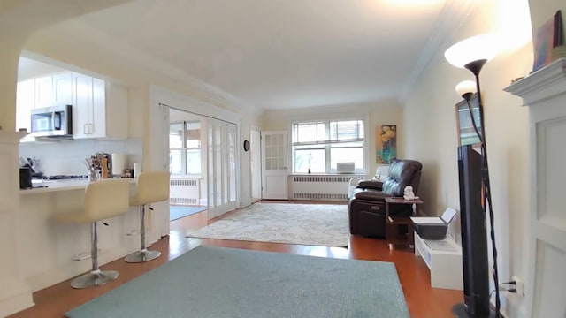 67-38 108st St Unit A53, Forest Hills, NY 11375 - living room featuring radiator, wood finished floors, and ornamental molding