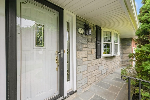 76 Roebling Pl E, Northport, NY 11731 - doorway to property featuring stone siding and a porch