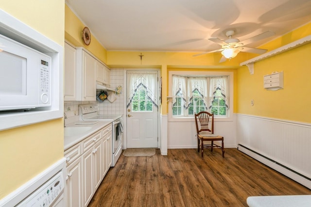 76 Roebling Pl E, Northport, NY 11731 - kitchen with white appliances, a baseboard heating unit, dark wood-style floors, white cabinets, and light countertops