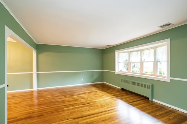 76 Roebling Pl E, Northport, NY 11731 - unfurnished room featuring radiator, crown molding, and wood finished floors