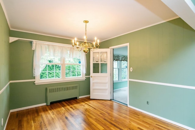 76 Roebling Pl E, Northport, NY 11731 - unfurnished dining area featuring radiator heating unit, a chandelier, wood finished floors, and ornamental molding