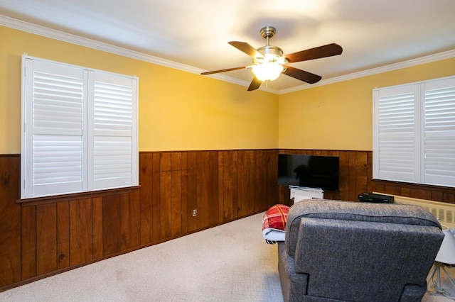 76 Roebling Pl E, Northport, NY 11731 - living area featuring wood walls, wainscoting, ornamental molding, ceiling fan, and carpet flooring