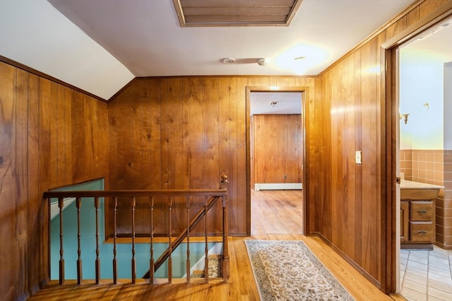 76 Roebling Pl E, Northport, NY 11731 - hallway featuring an upstairs landing, light wood finished floors, wooden walls, and vaulted ceiling