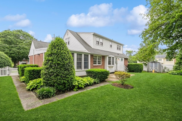 76 Roebling Pl E, Northport, NY 11731 - view of front of home featuring brick siding, a storage shed, and a shingled roof