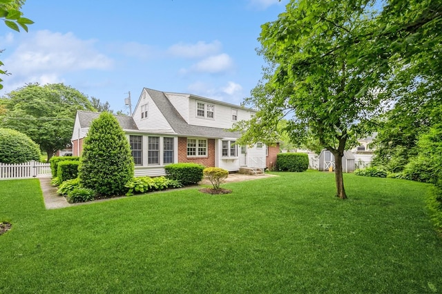 76 Roebling Pl E, Northport, NY 11731 - back of property with a storage unit, brick siding, a shingled roof, a chimney, and a patio area