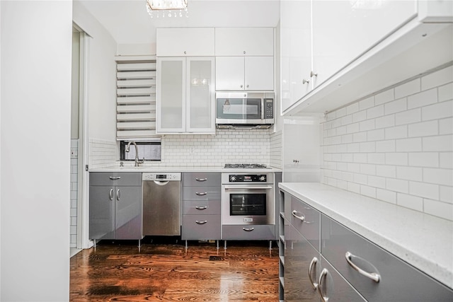 237 Eldridge St Unit 3 & 4, New York Manhattan, NY 10002 - kitchen with stainless steel appliances, gray cabinetry, backsplash, and dark wood-type flooring