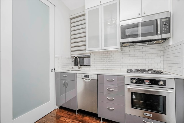 237 Eldridge St Unit 3 & 4, New York Manhattan, NY 10002 - kitchen featuring stainless steel appliances, gray cabinets, light countertops, decorative backsplash, and dark wood-style floors