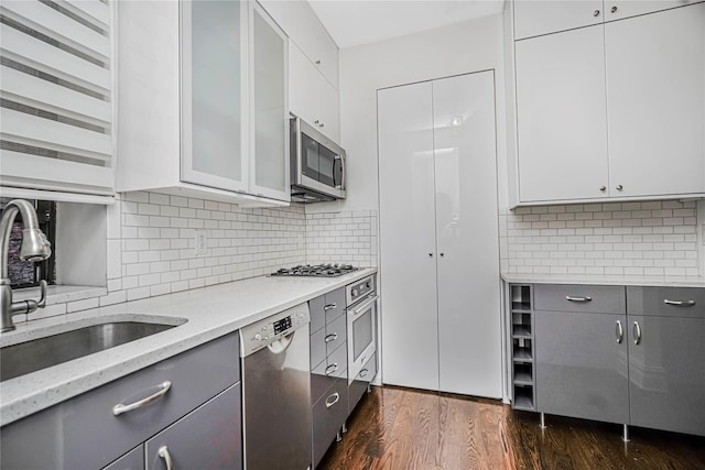 237 Eldridge St Unit 3 & 4, New York Manhattan, NY 10002 - kitchen featuring stainless steel appliances, gray cabinetry, light stone countertops, dark wood-style floors, and tasteful backsplash