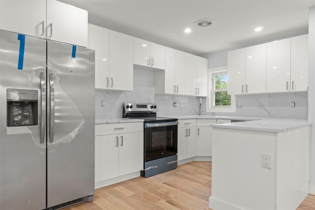 22019 135th Ave, Addisleigh Park, NY 11413 - kitchen with appliances with stainless steel finishes, light wood-style floors, tasteful backsplash, white cabinetry, and recessed lighting