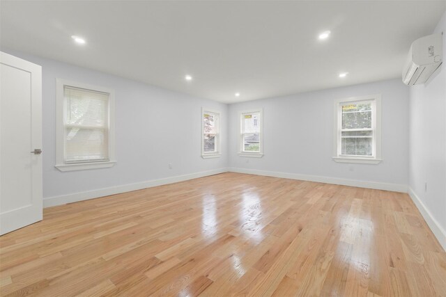22019 135th Ave, Addisleigh Park, NY 11413 - unfurnished room with a wall mounted AC, plenty of natural light, light wood-style floors, and recessed lighting