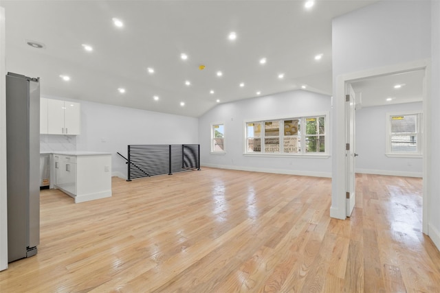 22019 135th Ave, Addisleigh Park, NY 11413 - unfurnished living room featuring light wood-type flooring, recessed lighting, lofted ceiling, and a barn door