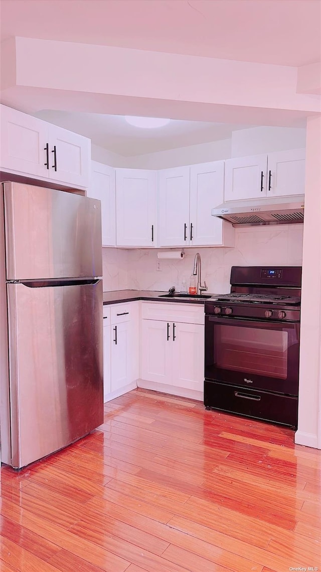 144-85 Roosevelt Ave Unit 5E, Flushing, NY 11354 - kitchen with freestanding refrigerator, black range with gas stovetop, under cabinet range hood, and light wood finished floors